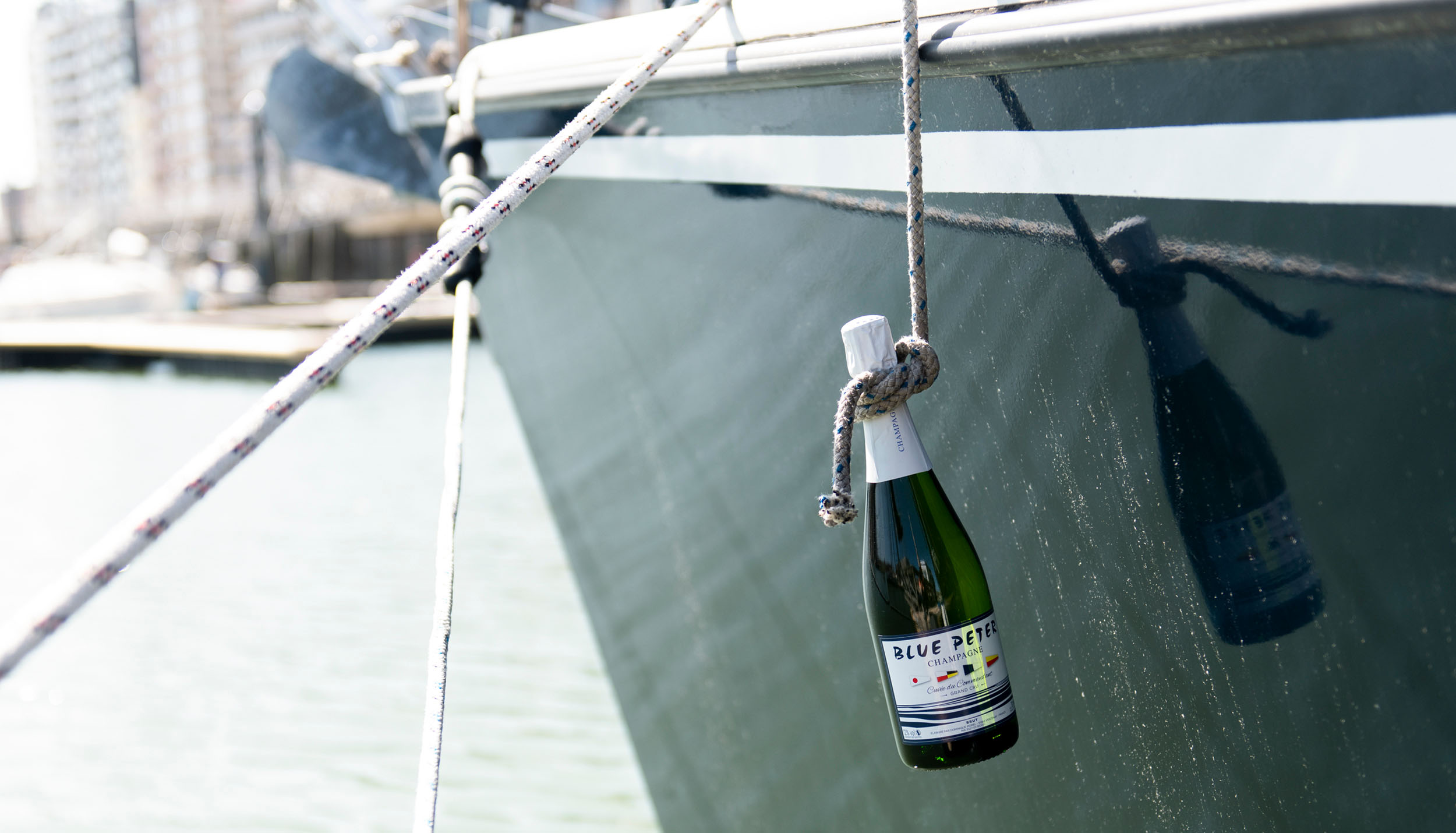 Fles champagne tegen boot